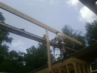 Carpenter setting a ridge beam over a new addition frame — Ice Dam Removal by Roofing Brothers in Eldorado