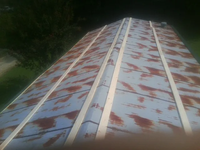 Rusted metal roof panels with new wood purlins before replacement — Storm Damage Roof Repair in Eldorado by Roofing Brothers