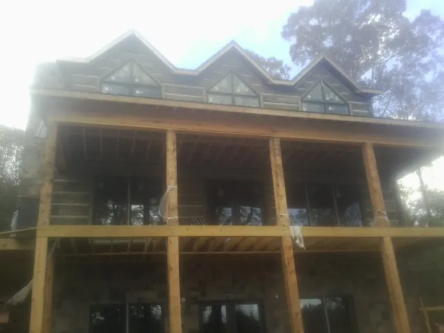Dormers and porch framing on a large log home under construction — Roof Coating work by our crew in Eldorado