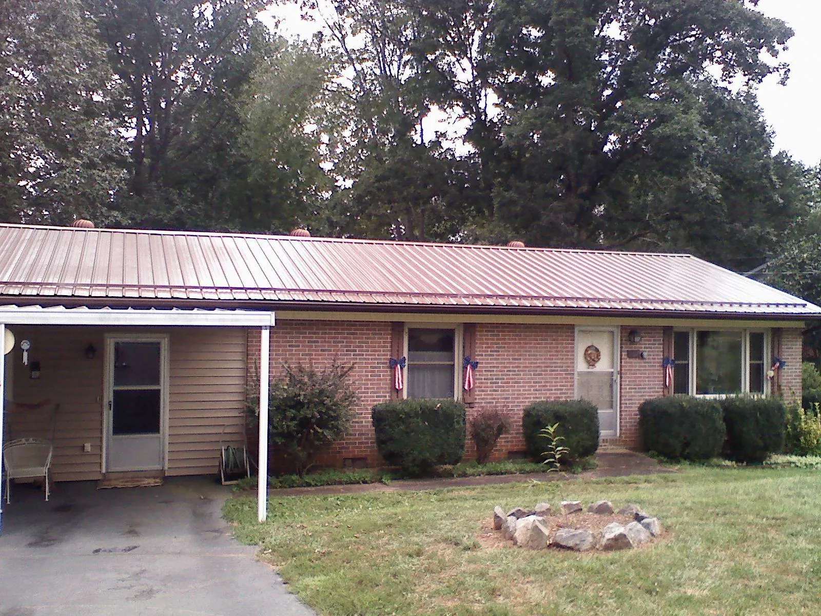 Bronze metal roof and carport on a brick ranch home — Roof Repair work by our crew in Eldorado